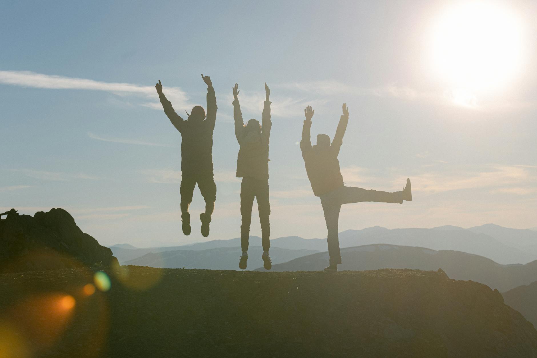 silhouette of people raising their hands